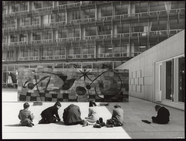 Photographie en noir et blanc de la fresque de Miro disposée devant un bâtiment