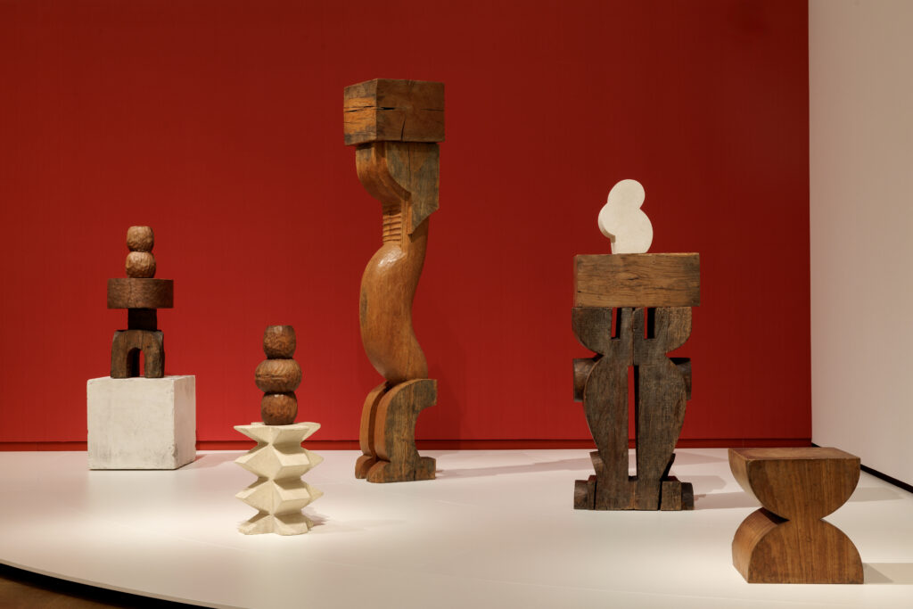 Wooden sculpture by Brancusi, arranged on a large white base.